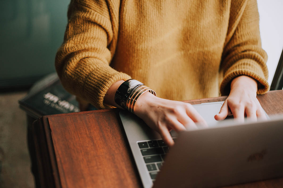 person typing on a laptop at their desk